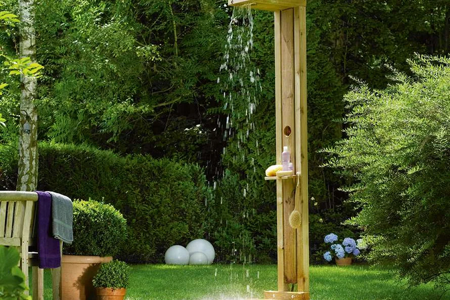 Holzdusche im Garten mit laufendem Wasser